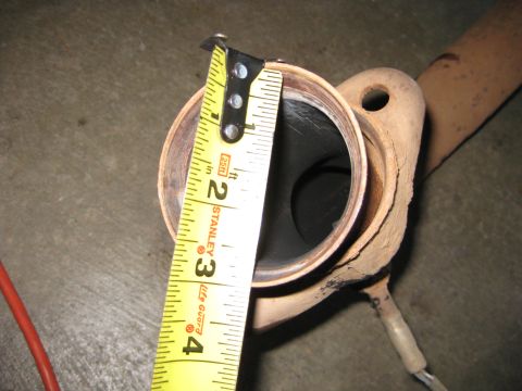 1995 Ford Bronco - Close-up of a cut exhaust pipe end on a concrete garage floor with a Stanley Lite Guard 25 ft tape measure laid across the opening to check…