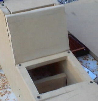 1999 Ford Taurus - Unfinished wooden center console tray cutout with visible screws and a hinged lid.