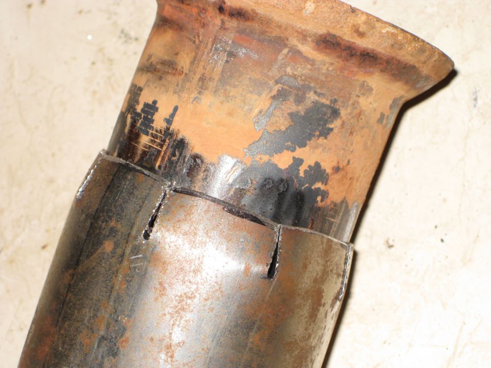 Close-up of a rusty exhaust pipe with cuts made for a Y-pipe connection