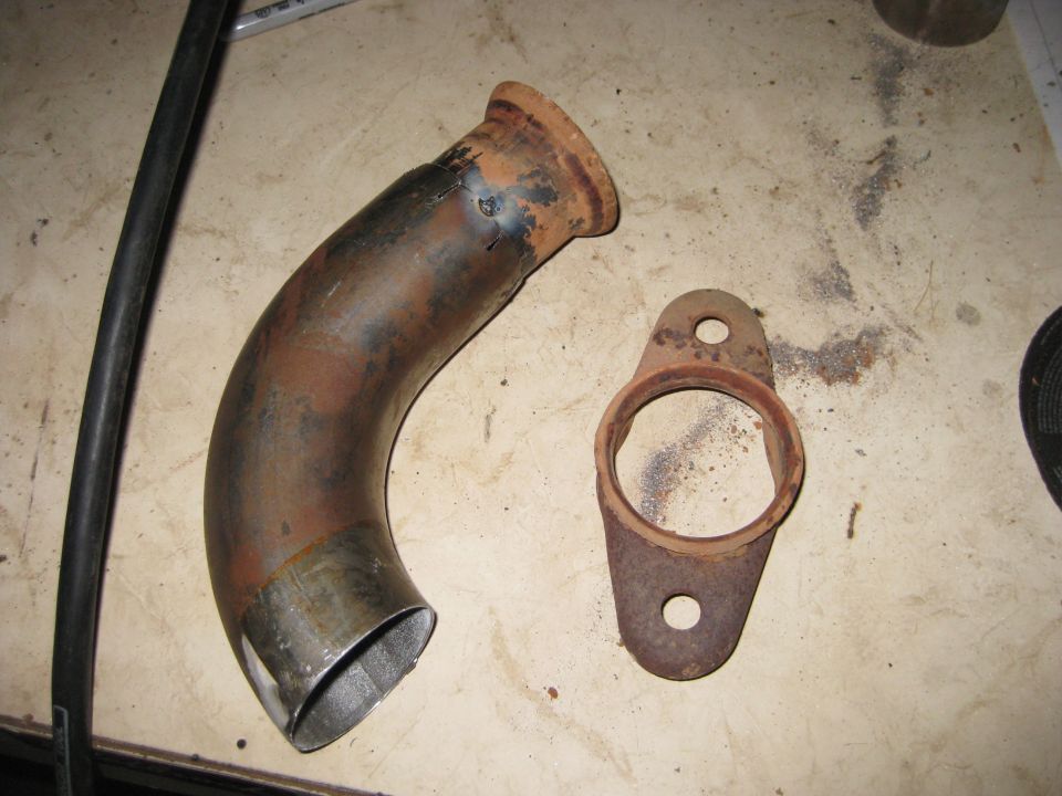 Rusty exhaust pipe and flange on a workbench