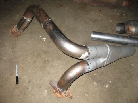 1995 Ford Bronco - A custom exhaust Y-pipe assembly, likely for a vehicle, is shown on a concrete surface.
