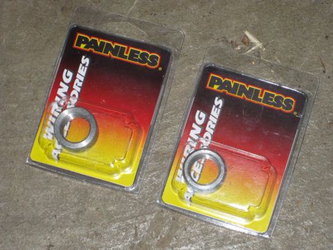 1995 Ford Bronco - Two packages of Painless Wiring Accessories, each containing a metal ring, are displayed on a concrete surface.