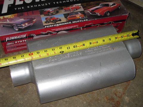 1995 Ford Bronco - A Flowmaster muffler is measured with a yellow tape measure, with the product box visible in the background.
