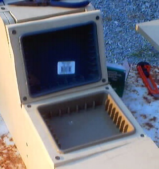 1999 Ford Taurus - A tan plastic center console tray cutout is shown with its lid open, revealing an empty storage compartment.