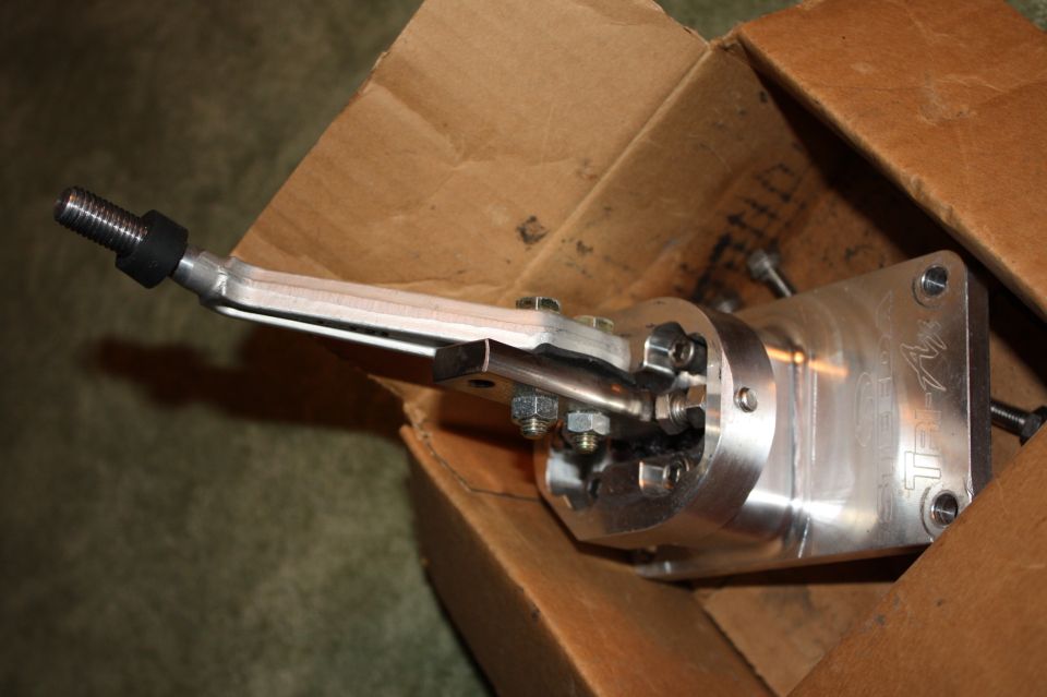 Aftermarket shifter mechanism with threaded rod and metal housing, in cardboard box