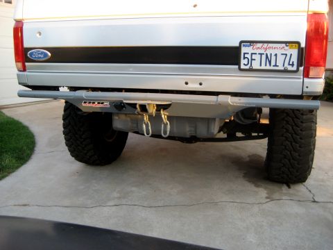 1996 Ford Bronco - Rear view of a silver 1996 Ford Bronco, showing its aftermarket bumper and hitch assembly.
