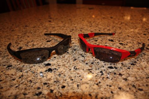 2004 Ford Mustang - Two pairs of sunglasses, one black and one red, rest on a granite countertop. A "SUPERMOTORS" logo is visible in the lower right corner.
