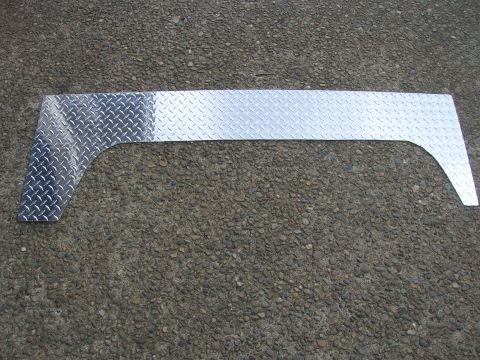 1996 Ford Bronco - A diamond plate metal trim piece lies on a gravel surface.