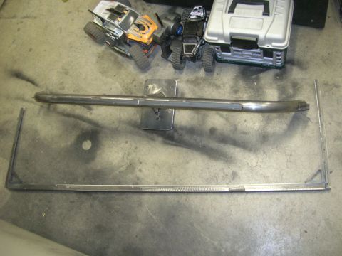 1996 Ford Bronco - A metal bar and frame lie on a concrete surface, with toy vehicles in the background.