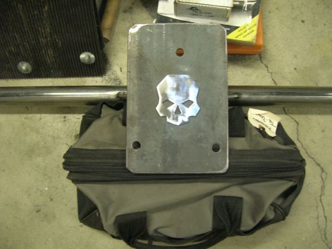 1996 Ford Bronco - A metal plate with a skull design is placed on a tool bag, with a metal bar in the background.