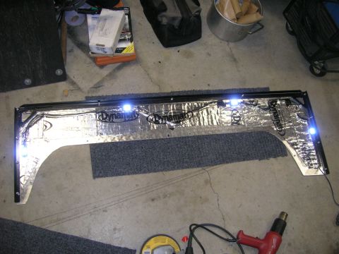1996 Ford Bronco - A modified spare tire mount, insulated with Dynamat and fitted with LED lights, sits on a garage floor.