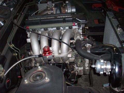 1992 Nissan 240SX - Close-up of a modified Nissan SR20DET engine, showing turbocharger and fuel pressure regulator.
