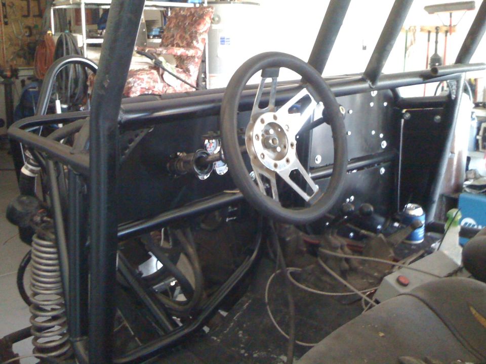 Custom off-road vehicle interior with roll cage and aftermarket steering wheel