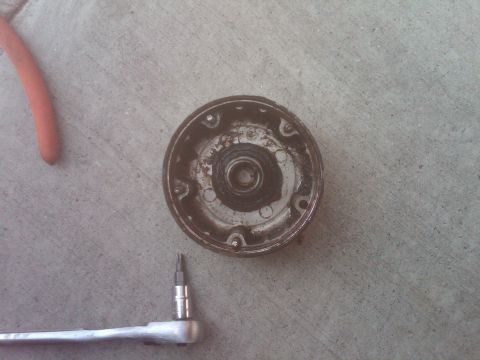 1982 Ford Bronco - A removed distributor cap and rotor sit on concrete next to a ratchet and hex bit tool, suggesting a repair or maintenance task.