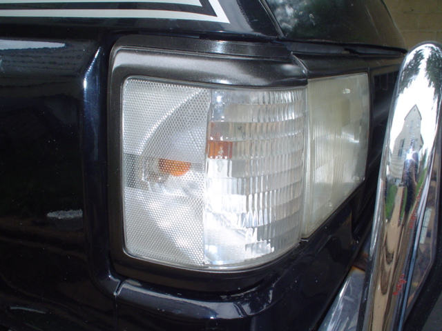 Black SUV front corner with chrome bumper and clear turn signal
