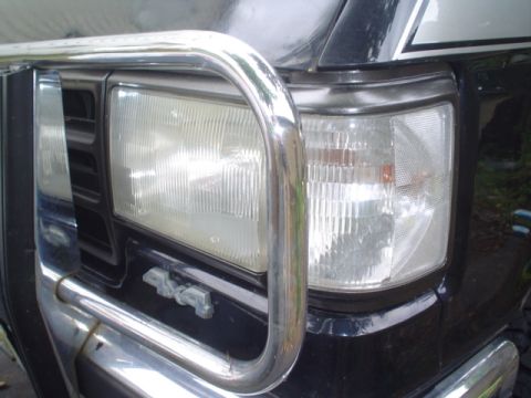 1988 Ford Bronco - Close-up of a black Ford Bronco's front end, a chrome bull bar and "4x4" badging.