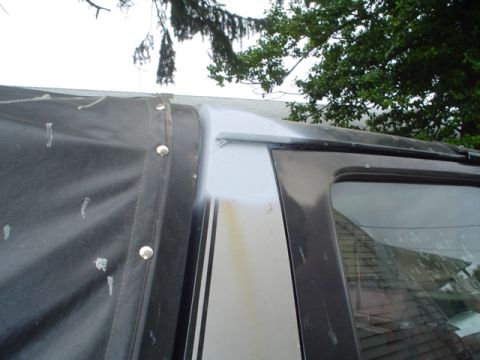1988 Ford Bronco - Detail of a vehicle's soft top and window frame, showing a Supermotors watermark at the bottom right.