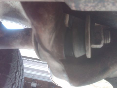 1982 Ford Bronco - Underside view of a vehicle, focusing on a suspension part and a tire.