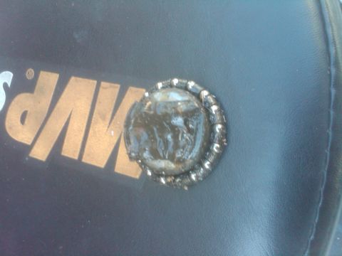 1982 Ford Bronco - A close-up shot of an emblem on a dark surface, possibly a vehicle interior.