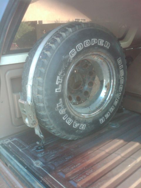 1982 Ford Bronco - Spare tire with Cooper Discoverer Radial text mounted in cargo area.