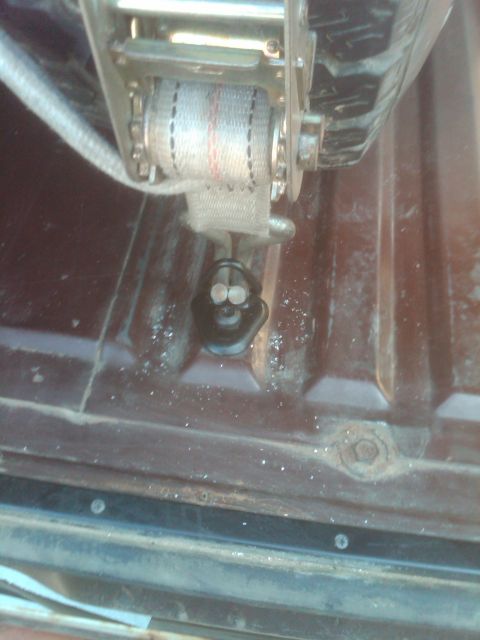 1982 Ford Bronco - A ratchet strap is shown secured in the bed of a vehicle, likely a truck.