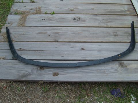 1992 Ford Bronco - A curved black trim piece, likely for a vehicle, is shown laid out on wooden planks.