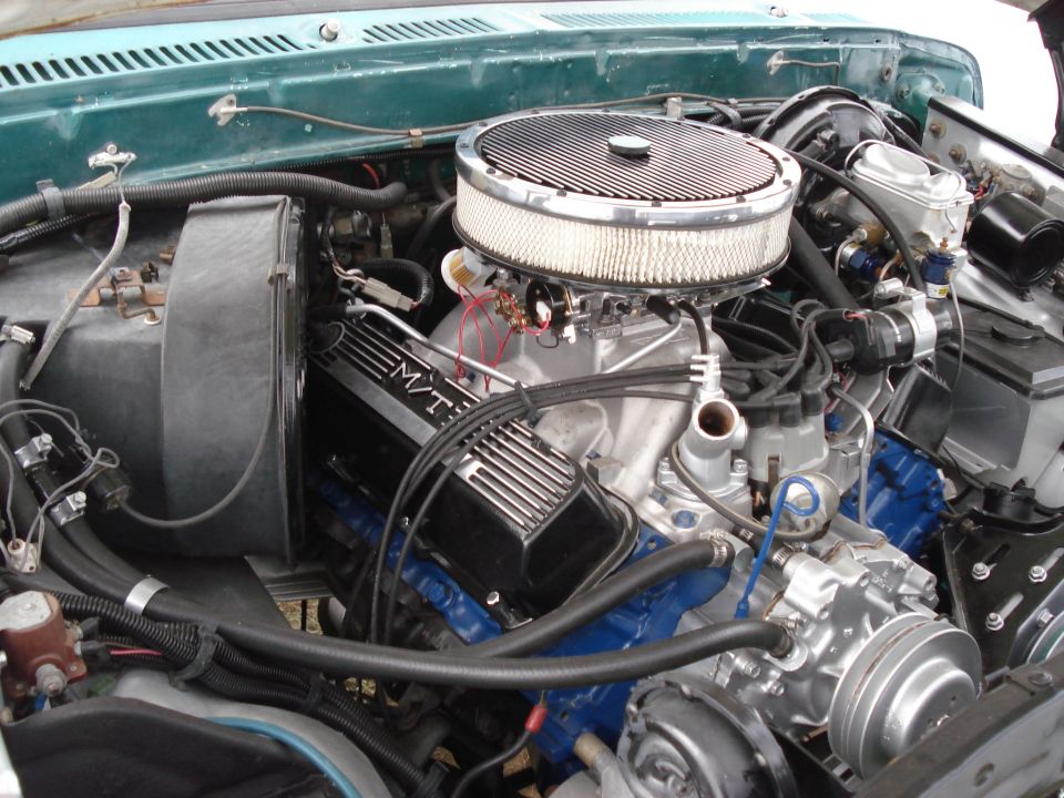 Close-up of a V8 engine with M/T valve covers and a large air cleaner