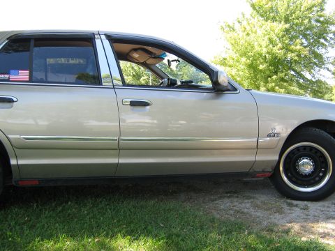 2000 Mercury Grand Marquis - This 2000 Mercury Grand Marquis is seen from the side, an American flag sticker on the rear window.