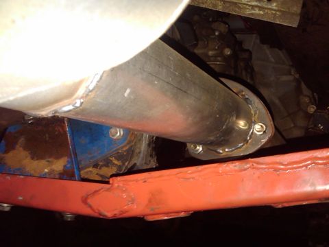 1978 Ford Bronco - Close-up view of an exhaust pipe connected to a vehicle's transmission.