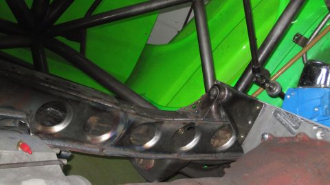 1995 Ford Bronco - Close-up of custom suspension parts and frame modifications, with bright green bodywork visible.