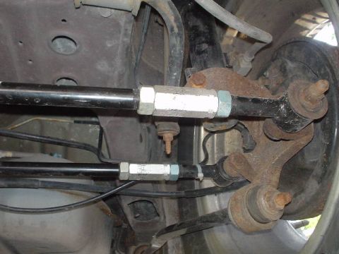 1999 Ford Taurus - Close-up view of aftermarket rear suspension components, including adjustable control arms and a brake drum.