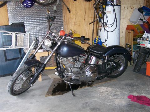 1988 Suzuki Samurai - A dark blue motorcycle with chrome accents is parked in a garage.