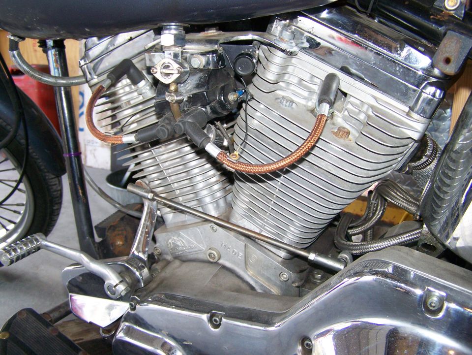 Close-up of a motorcycle engine with chrome accents and copper-colored spark plug wires