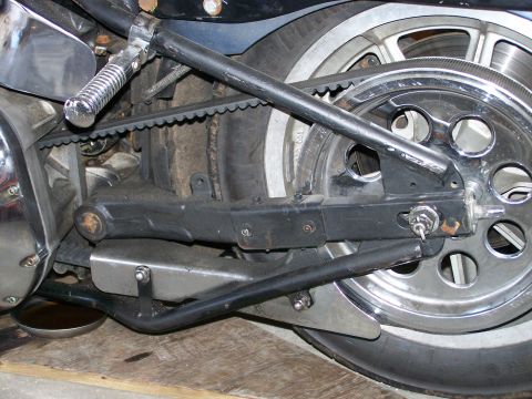 1988 Suzuki Samurai - Close-up view of a motorcycle's rear drive belt, wheel, and suspension components.