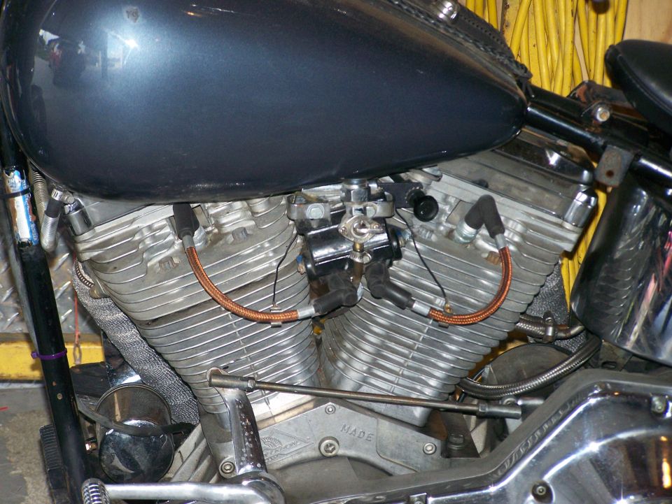 Close-up of a V-twin motorcycle engine with copper spark plug wires
