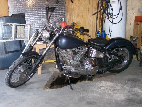 1988 Suzuki Samurai - A dark blue motorcycle with chrome accents is parked in a garage.