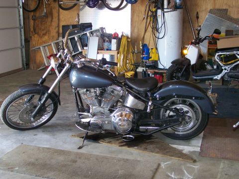 1988 Suzuki Samurai - A custom motorcycle sits in a garage, with a scooter and other items visible in the background.