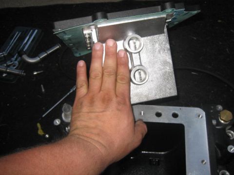 1996 Ford Thunderbird - A hand is shown next to a metal automotive part, likely for scale or demonstration.