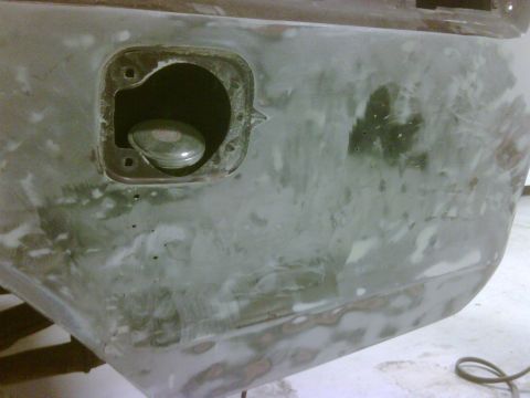 1979 Ford F-250 - Close-up of a vehicle's body panel showing a fuel filler door opening, prepared for paint.