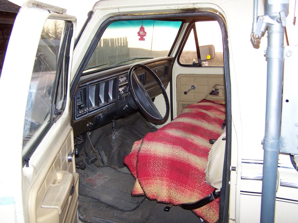 1979 Ford F-250 interior showing dashboard, steering wheel, and blanket-covered seat