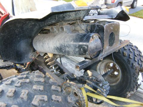 2000 Ford E350 - Close-up of an ATV's rear suspension and exhaust system, showing wear and tear.