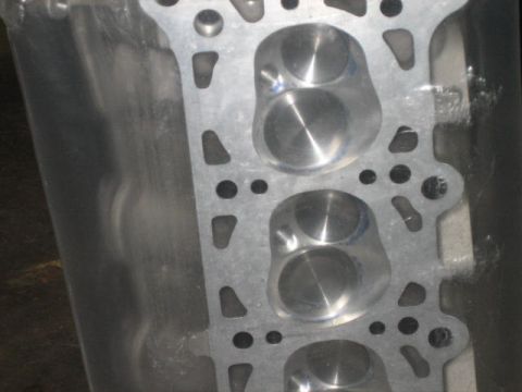 1996 Ford Thunderbird - Close-up of an aluminum engine cylinder head, showing valve openings and bolt holes.