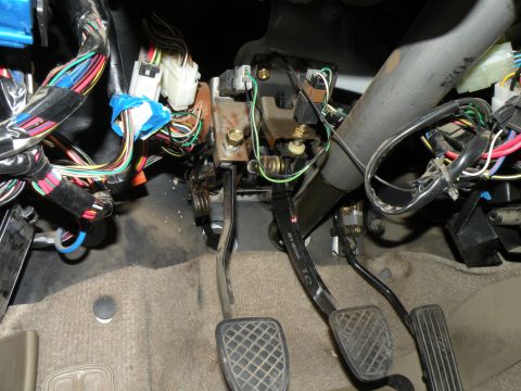 1998 Subaru Legacy - Close-up of the interior showing the brake, clutch, and accelerator pedals along with a dense network of electrical wiring.