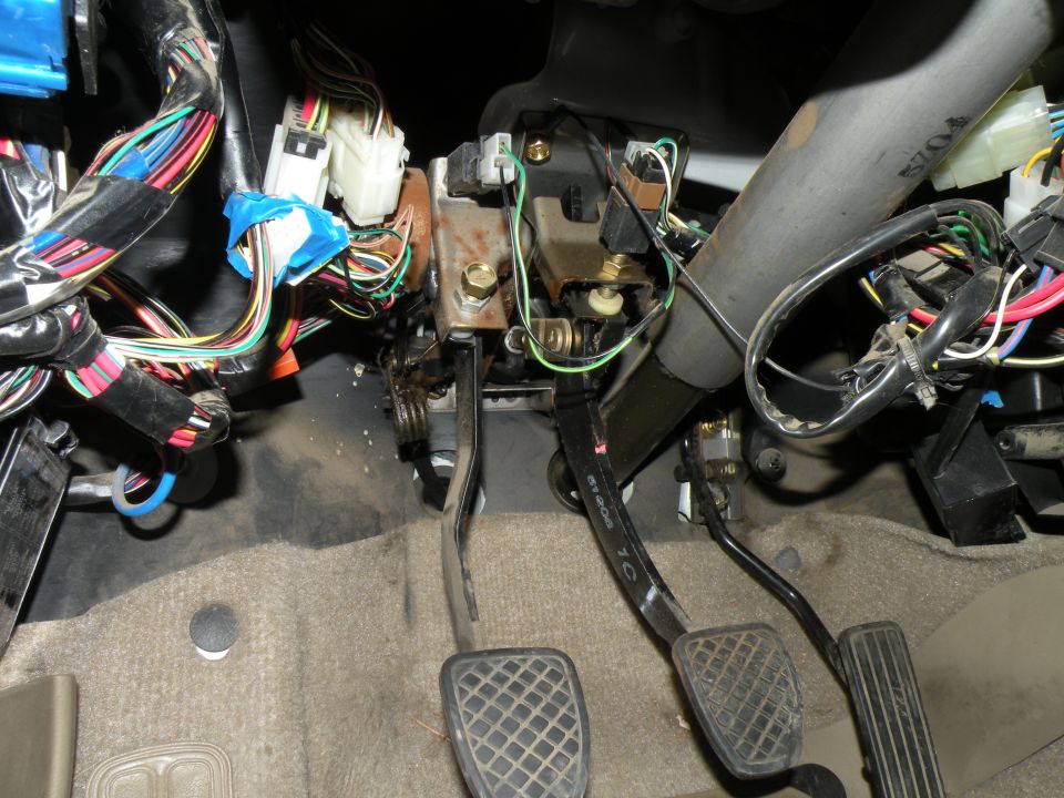 Interior view of car pedals and complex wiring harness