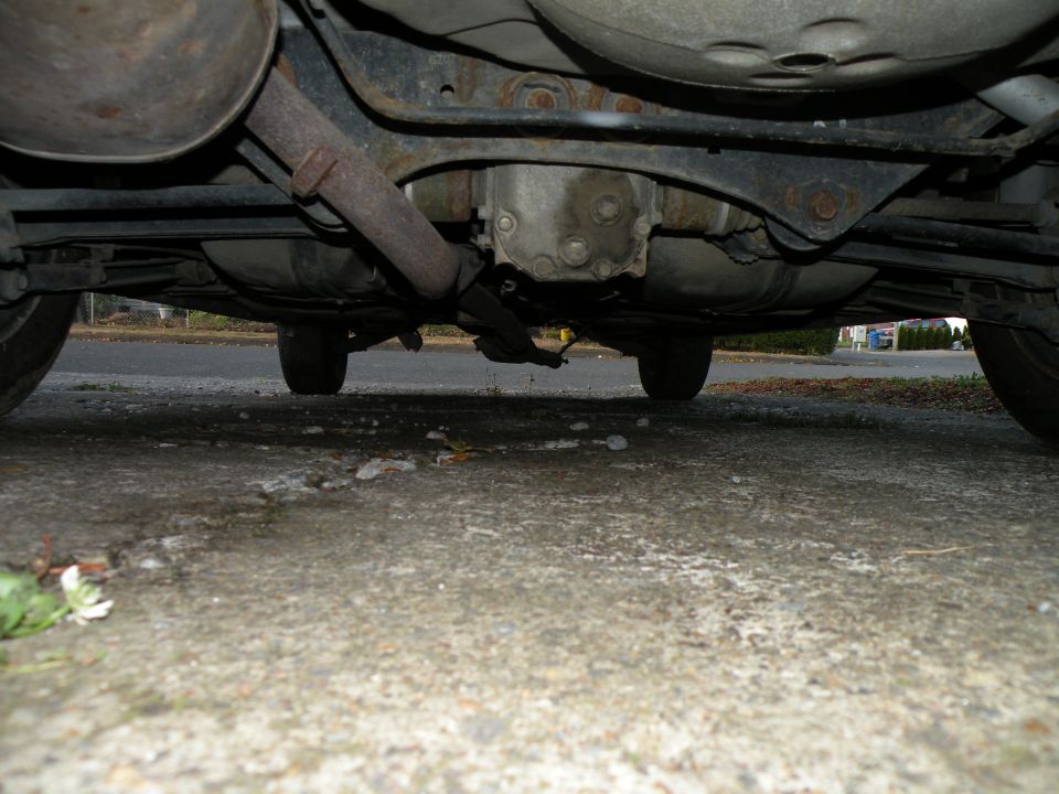 Underside of a car showing the exhaust and drivetrain components