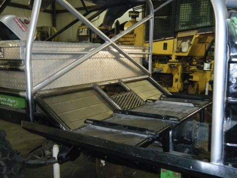 1978 Ford Bronco - Custom truck bed modifications including diamond plate, roll cage, and toolboxes are visible, with yellow heavy machinery in the background.