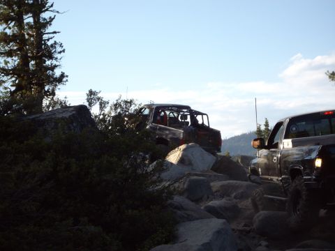 1982 Toyota 4Runner - Two off-road vehicles traverse a challenging rocky path, with one appearing to be an older model SUV.