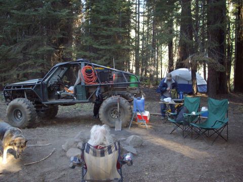 1982 Toyota 4Runner - Off-road buggy at a campsite in the woods, with camping gear and a tent visible.