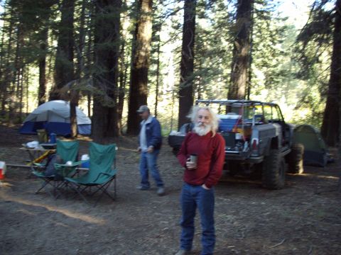 1982 Toyota 4Runner - A man stands in front of a modified off-road vehicle at a campsite in a forest.