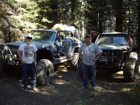 1982 Toyota 4Runner - Two men pose with their custom off-road vehicles in a forest setting.